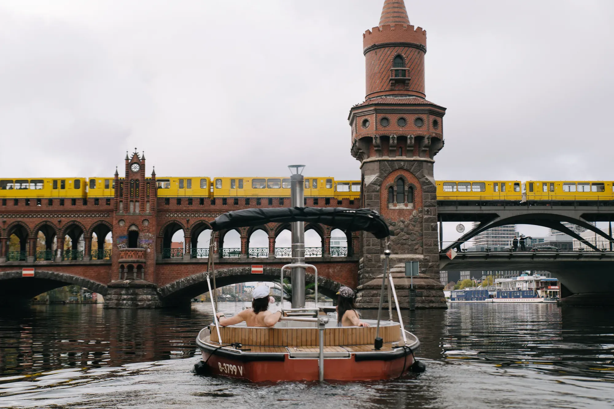Badedampfer vor der Oberbaumbrücke, dahinter eine gelbe U-Bahn